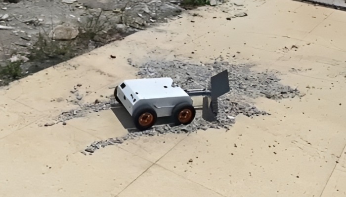Top view of robot plowing debris on concrete slab